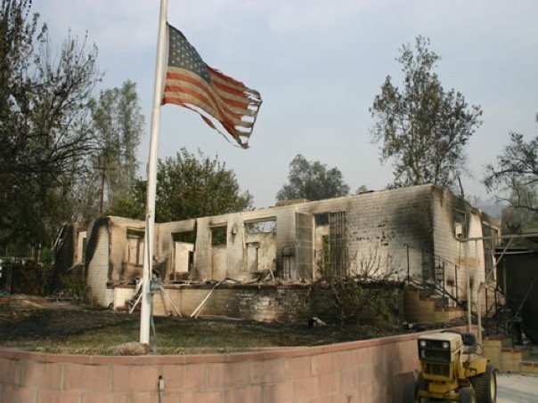 The burned remains of our home after the California wildfire, American flag still standing